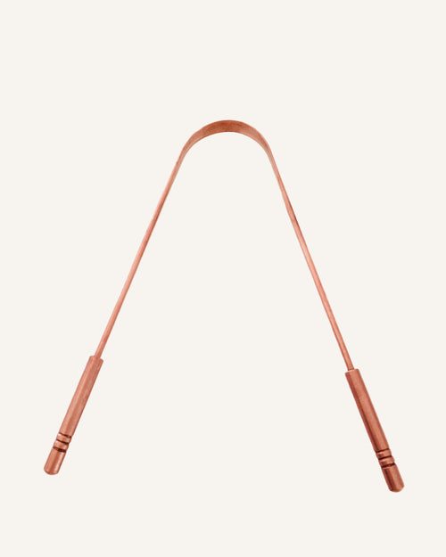 Copper Tongue Scraper on cream backdrop